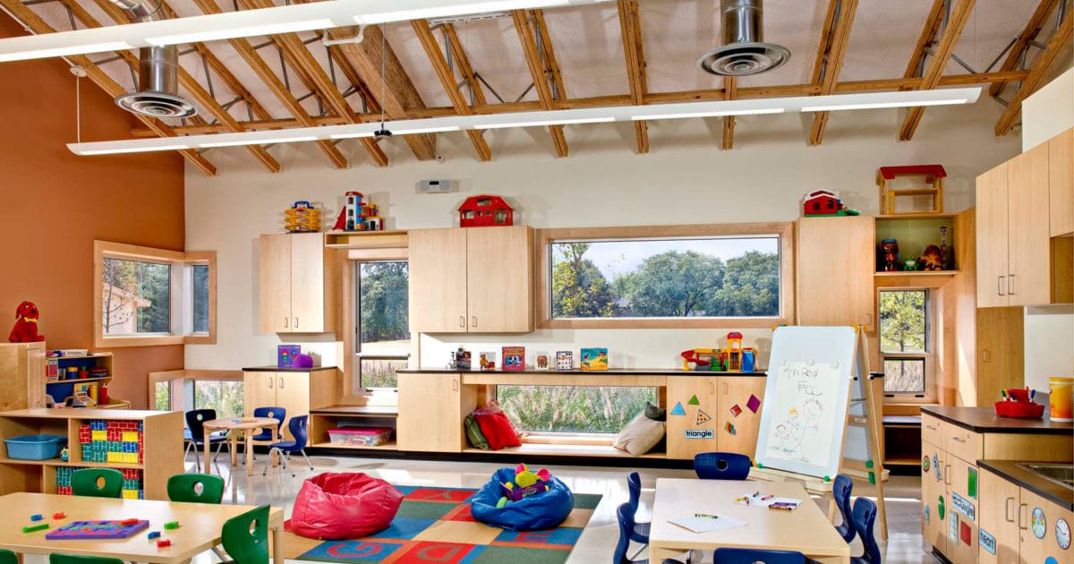 Bright classroom interior at Ann Reid Early Childhood Center in Naperville, Illinois, featuring play areas, child sized tables, and learning stations