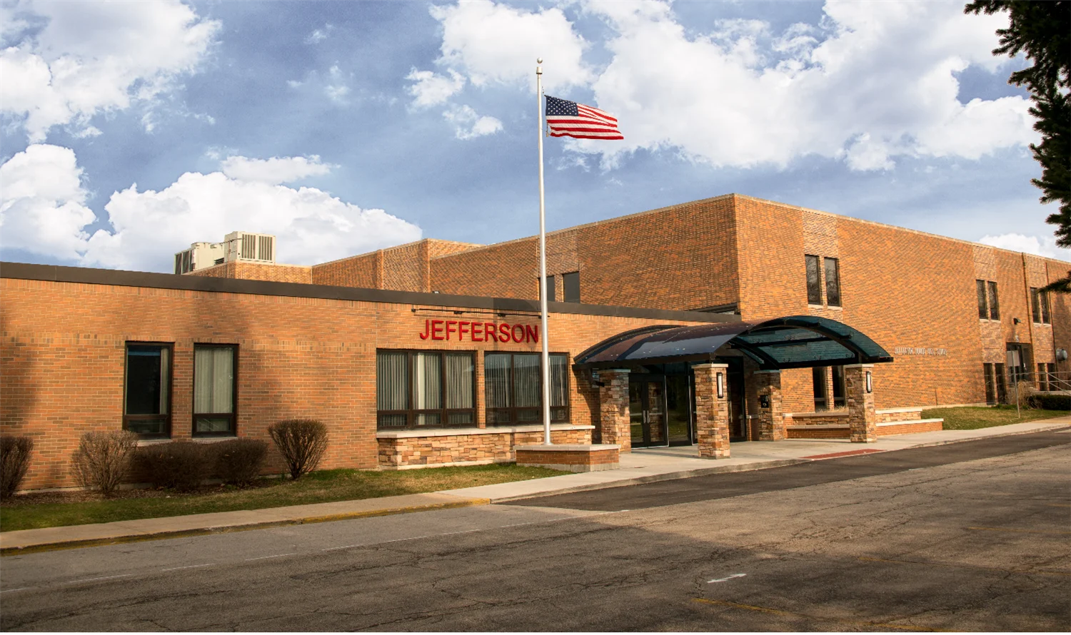 Exterior of Jefferson Junior High School in Naperville, Illinois with American flag and main entrance