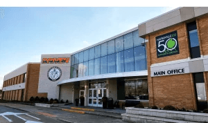 Modern exterior entrance of Naperville North High School featuring the Huskies logo and glass facade.