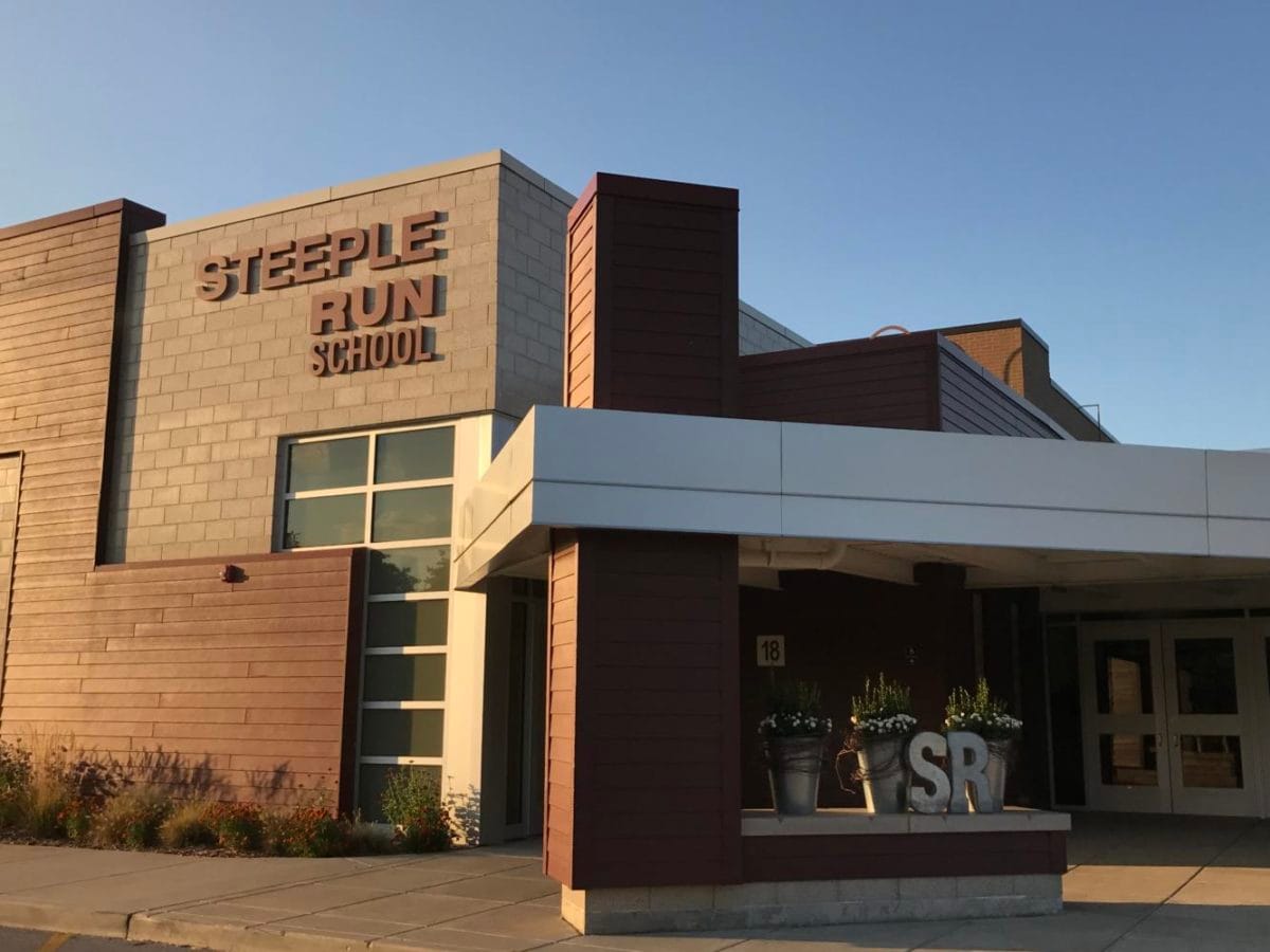 Modern exterior entrance of Steeple Run Elementary School in Naperville featuring the school sign and SR letters.