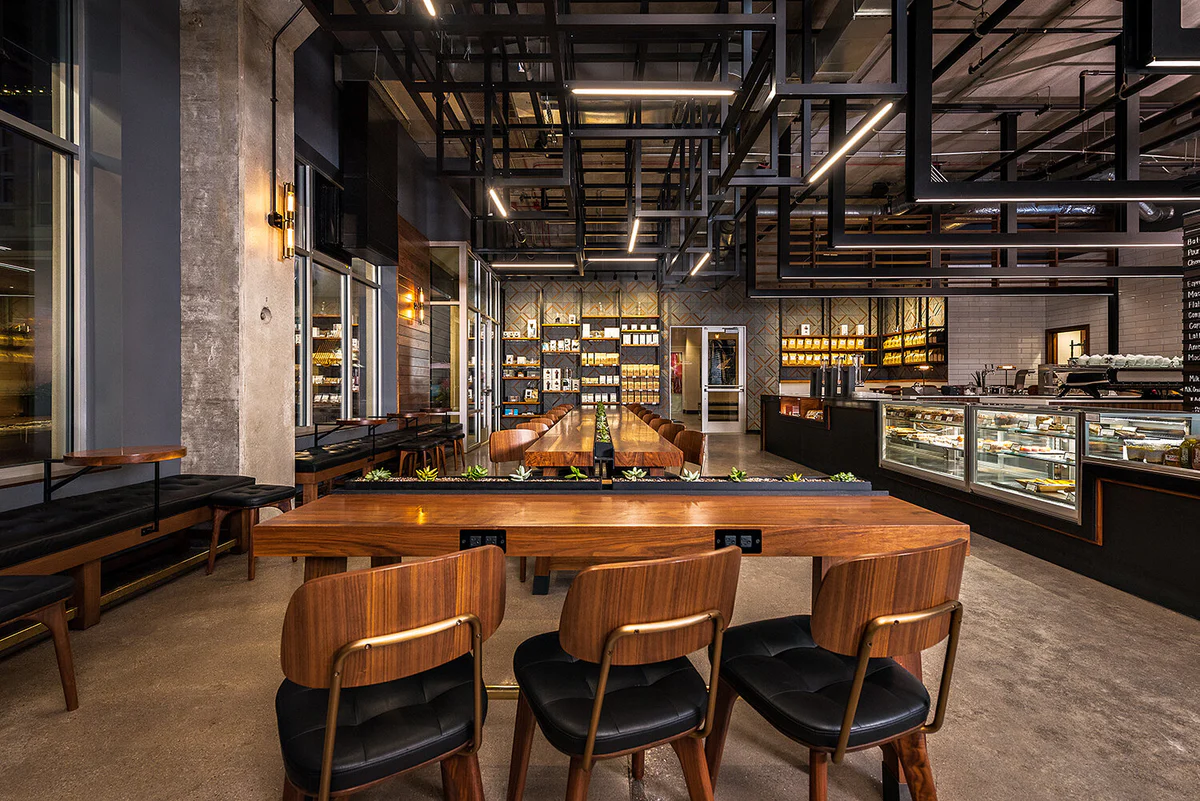 Modern interior of Sparrow Coffee in Naperville featuring communal tables, contemporary lighting, and a pastry counter