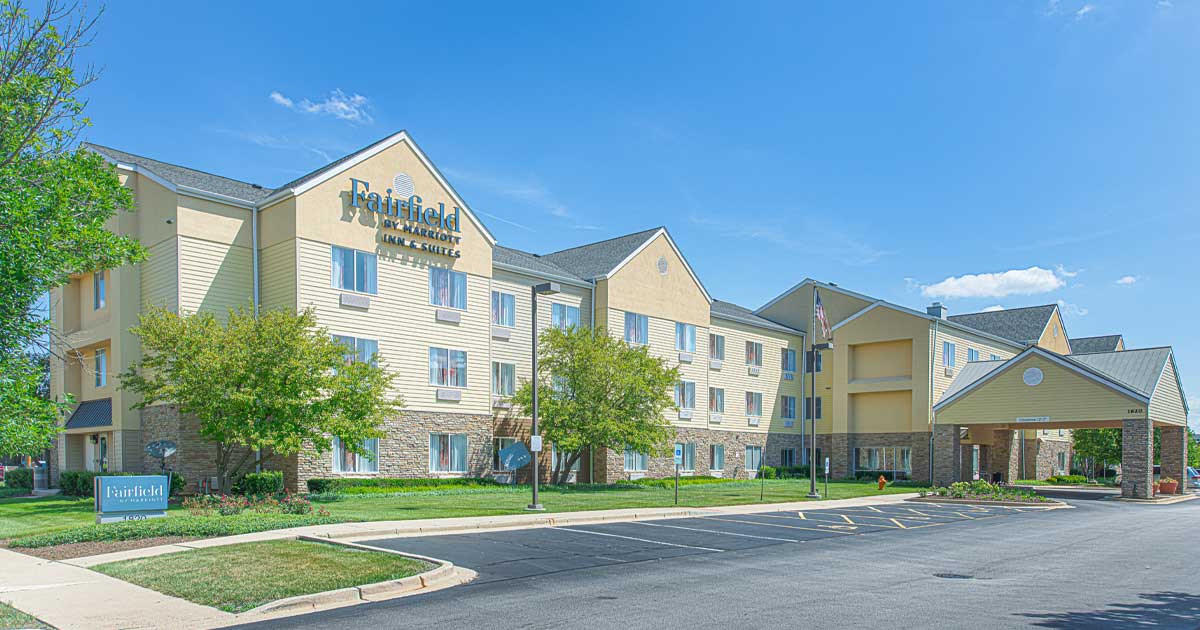 Fairfield Inn and Suites East Naperville hotel exterior with landscaped grounds and covered front entrance.