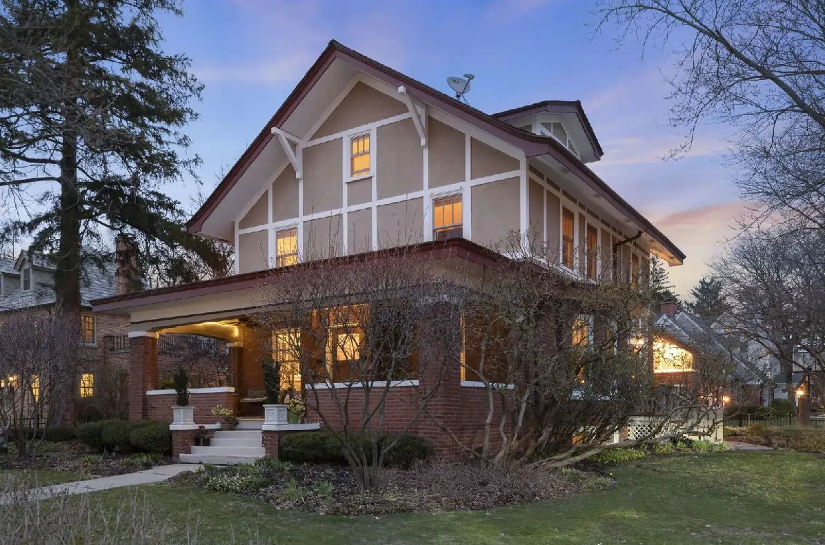 Neighborhoods 5 Two story brick and stucco home with a covered front porch at dusk in the Fort Hill neighborhood of Naperville Illinois