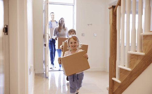 Family moving into a new home with boxes for Reliable Radon Inspections radon testing services in the Naperville area.