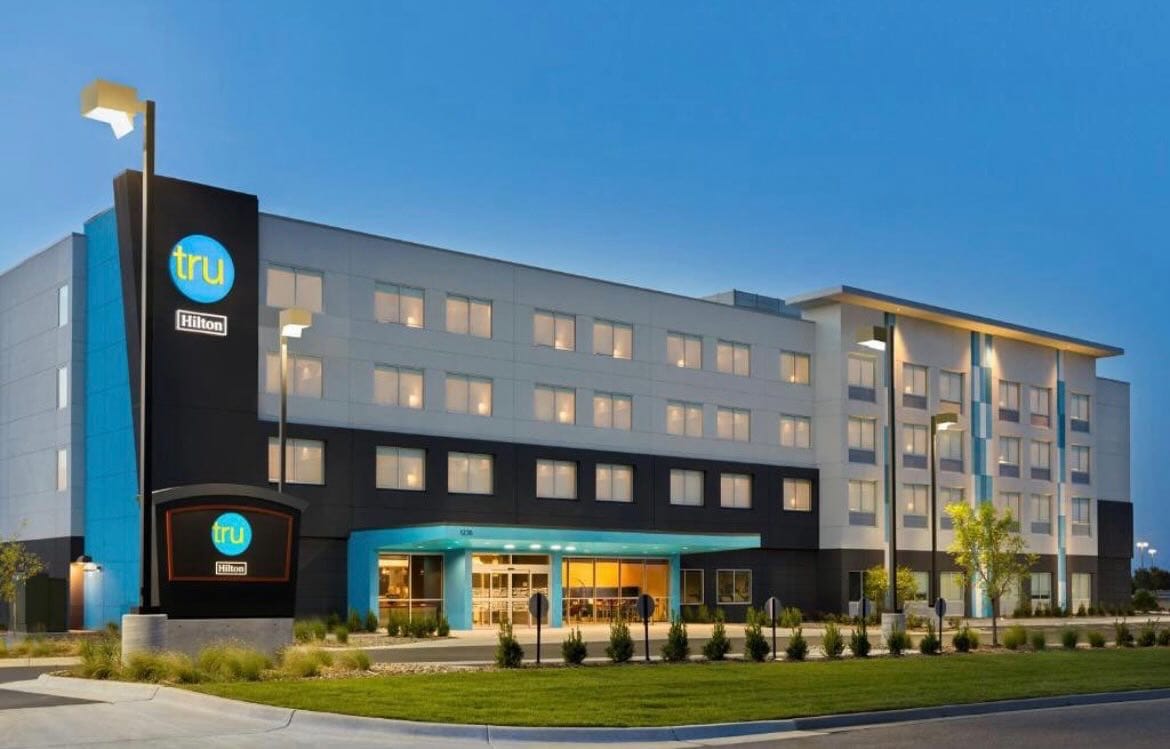 Places to Stay 2 Tru by Hilton hotel exterior in Naperville, Illinois with modern design and illuminated entrance.