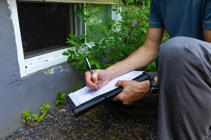 Indoor environmental inspector taking notes during an exterior foundation and window inspection at a Naperville home.