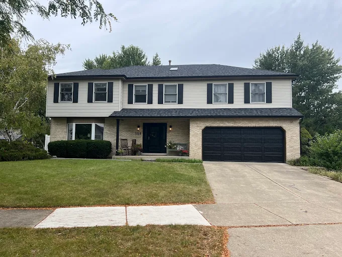 Black residential garage door installed by All Style Door on a two-story Naperville area home with front driveway.