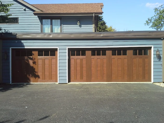 Wood look residential garage doors installed by All Style Door on a blue Naperville area home with asphalt driveway.