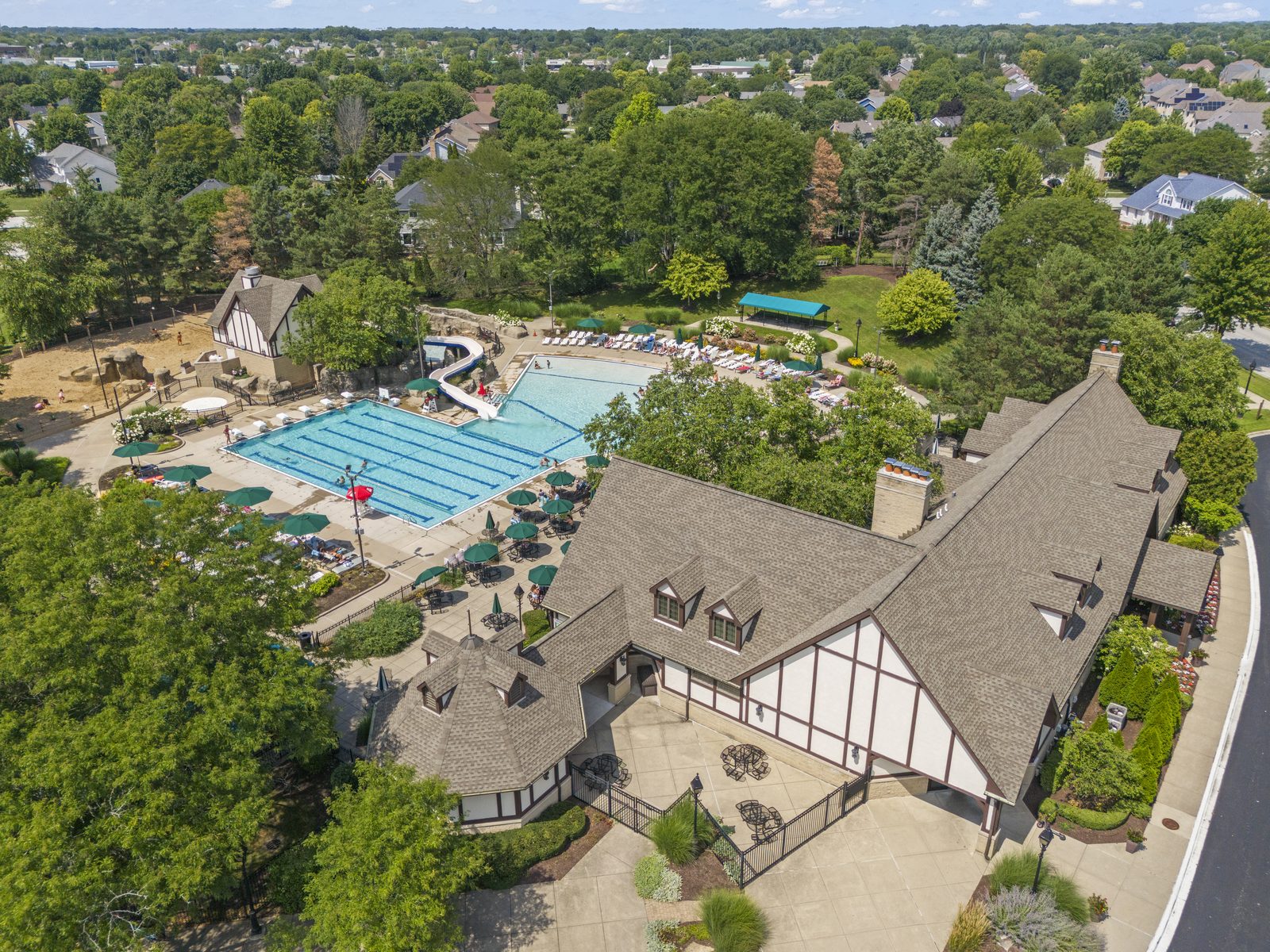 Ashbury Naperville Neighborhood Guide: Pool, Parks, Schools and Homes 2 Tudor style Ashbury clubhouse beside the lap pool and water slide in Naperville