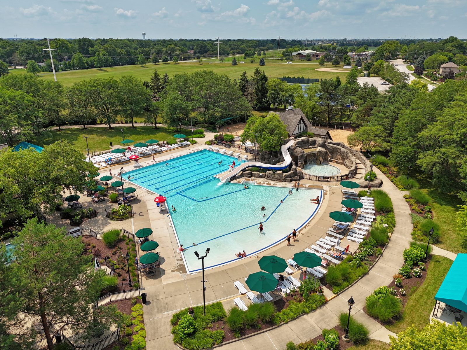 Ashbury Naperville Neighborhood Guide: Pool, Parks, Schools and Homes 3 Ashbury pool with lap lanes, a shallow play area, a water slide and rock feature in Naperville