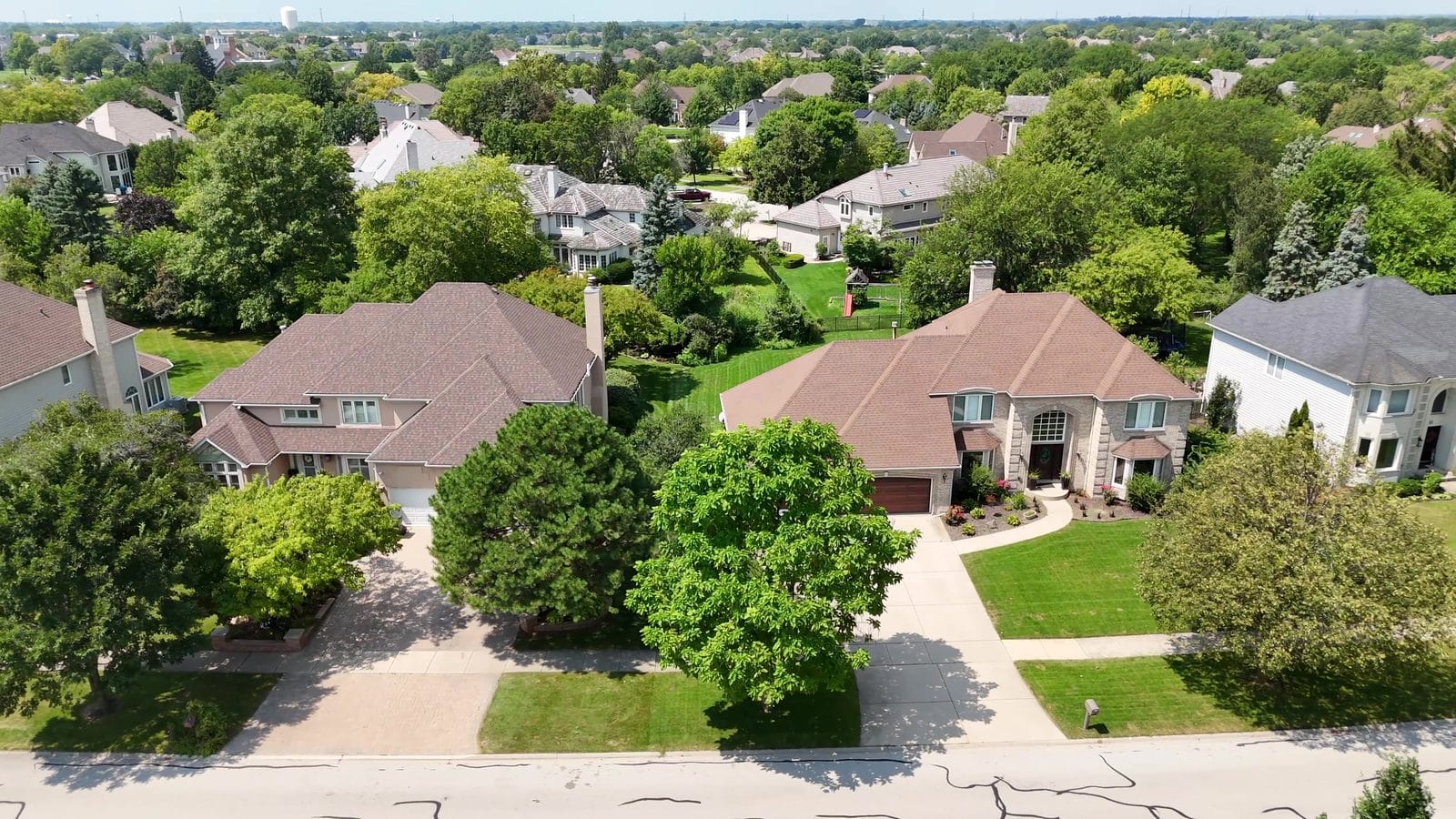 Buying a house contingent on selling yours: aerial of two Naperville two-story homes and lawns