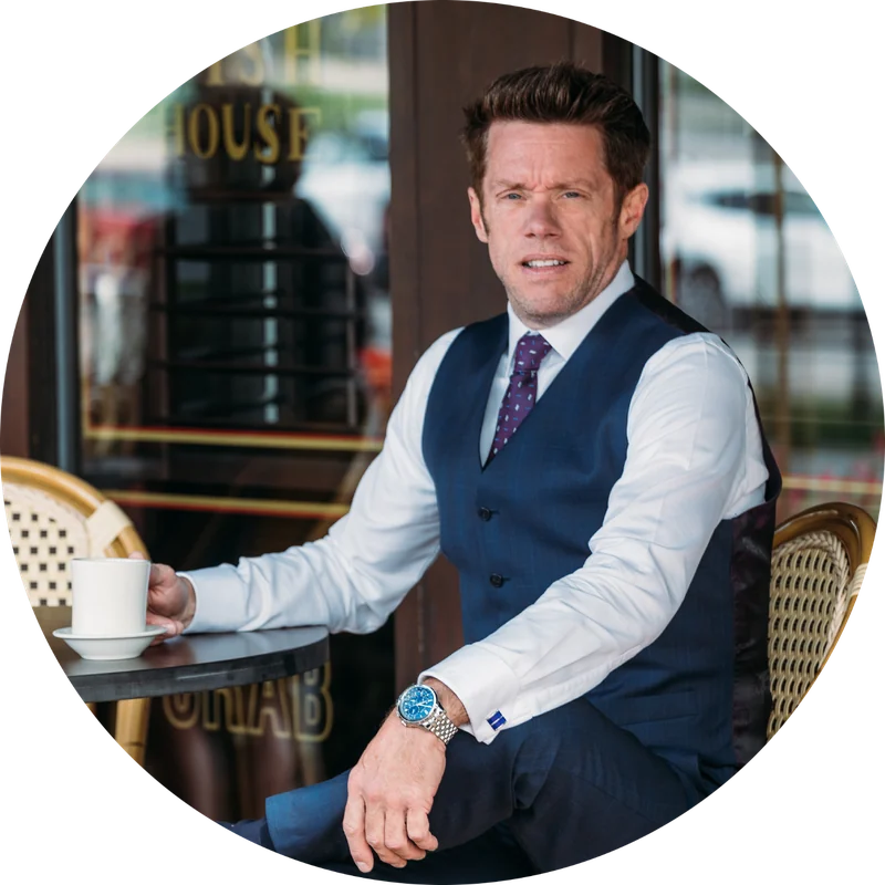 Dan Firks, Naperville real estate agent, seated at a sidewalk cafe table with a cup of coffee