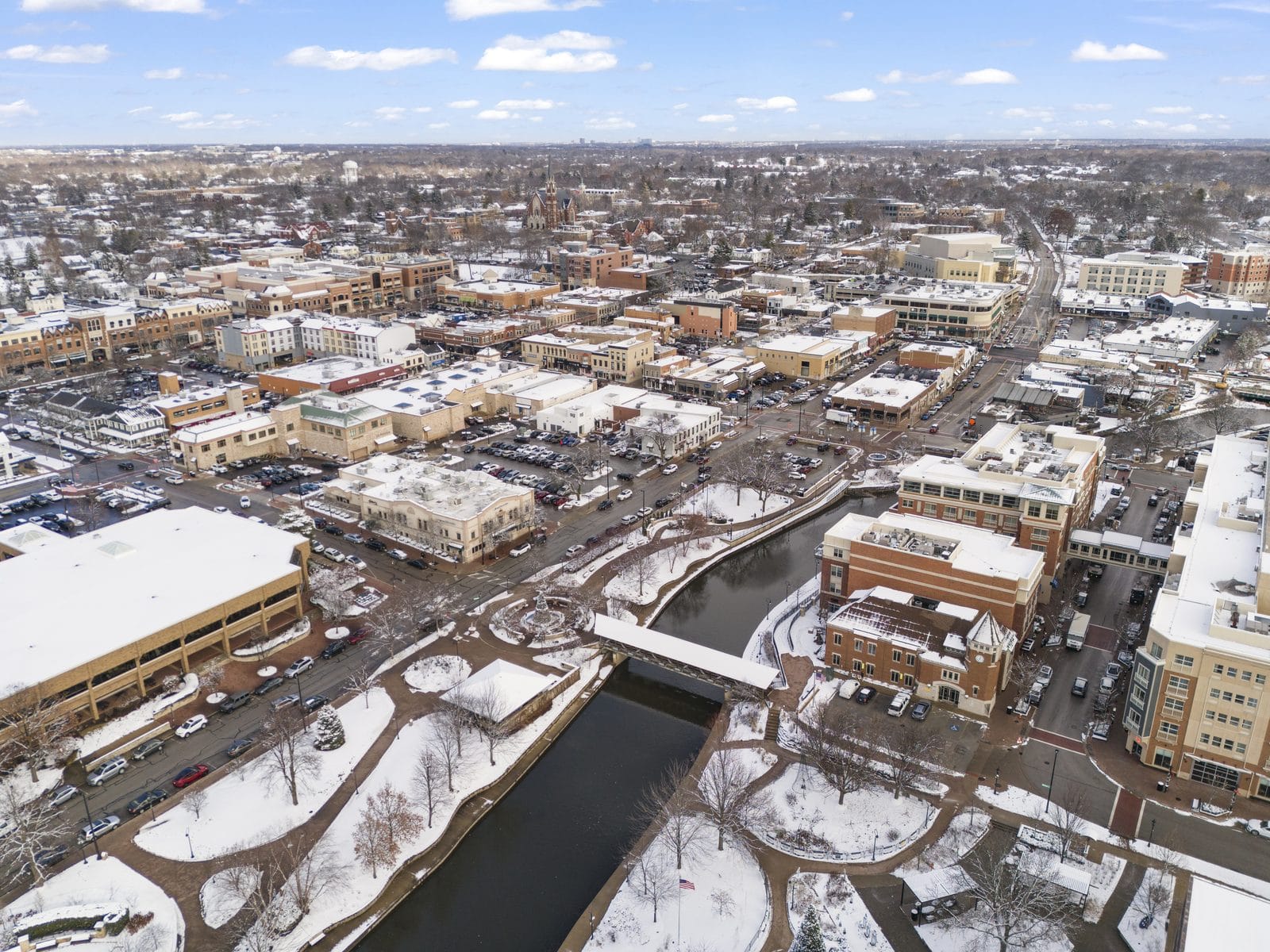 Downtown Naperville Under Snow, Aerial View of the Riverwalk in Winter Snow-covered downtown Naperville and the DuPage River Riverwalk seen from the air in winter