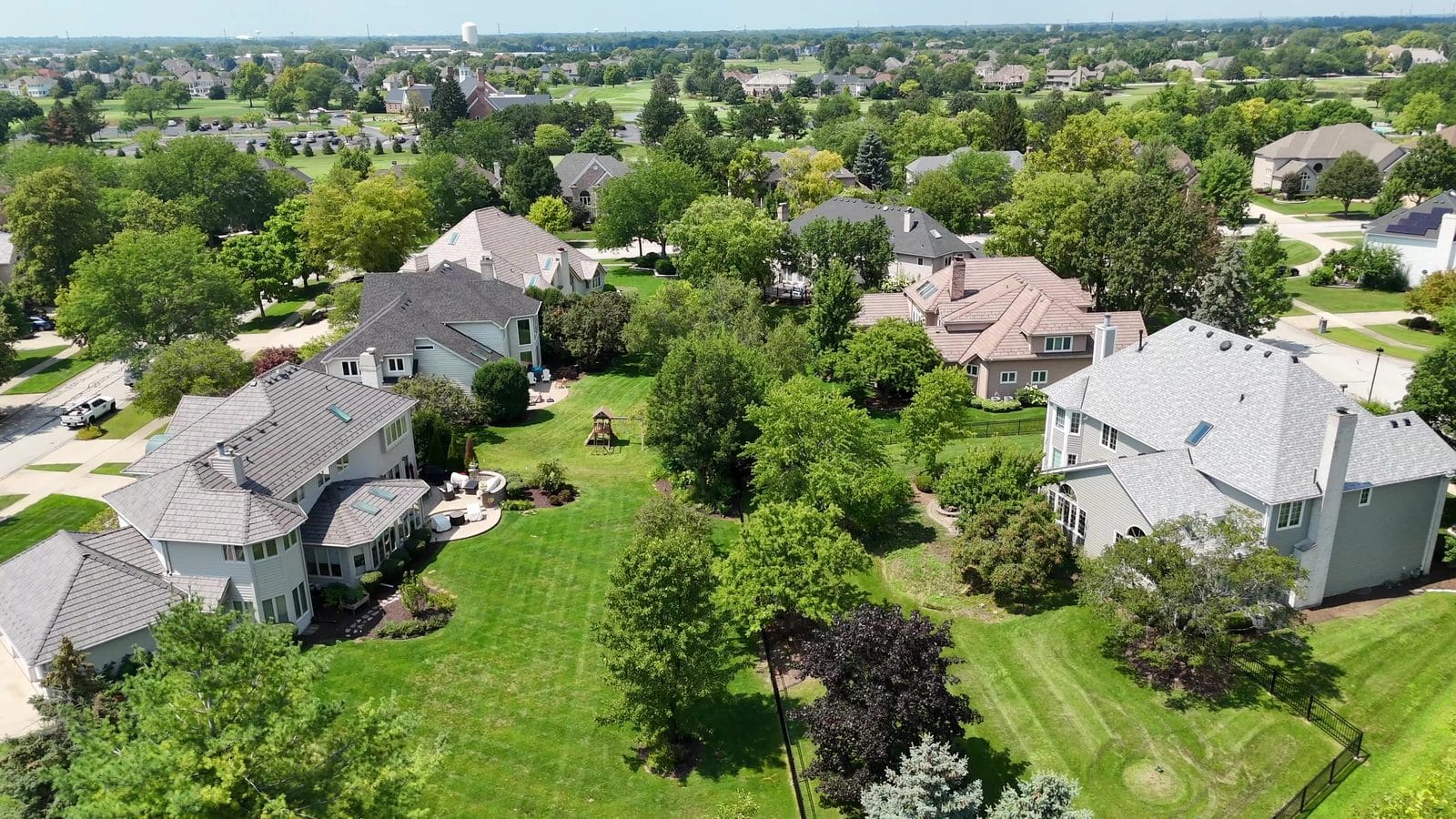 Five-year rent vs buy costs in Naperville: aerial of two-story homes and landscaped backyards