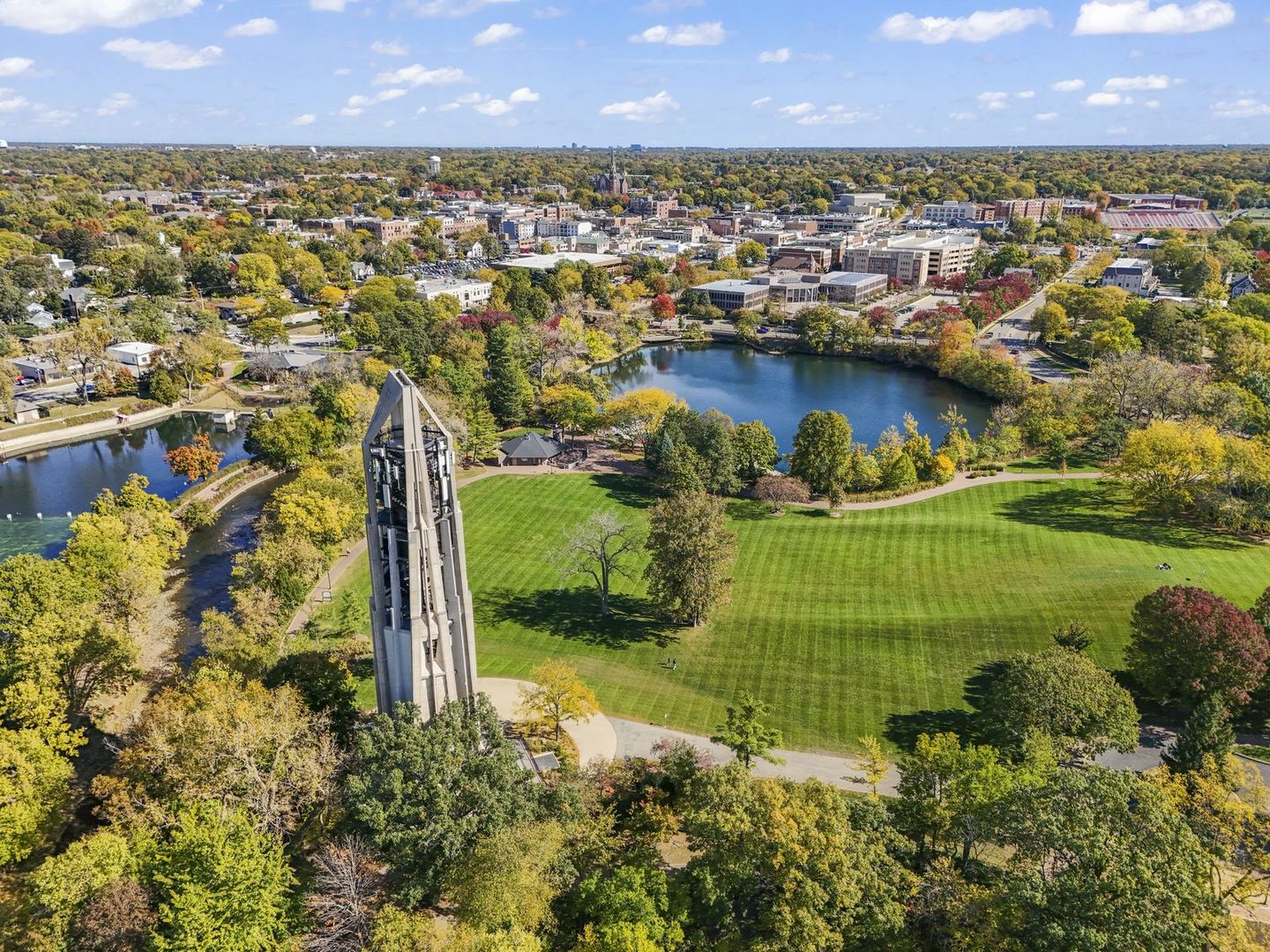 Naperville Halloween and Fall Events 2026: Things to Do Oct 10 to Nov 5 2 Moser Tower beside a wide green lawn, a quarry lake and downtown Naperville in fall