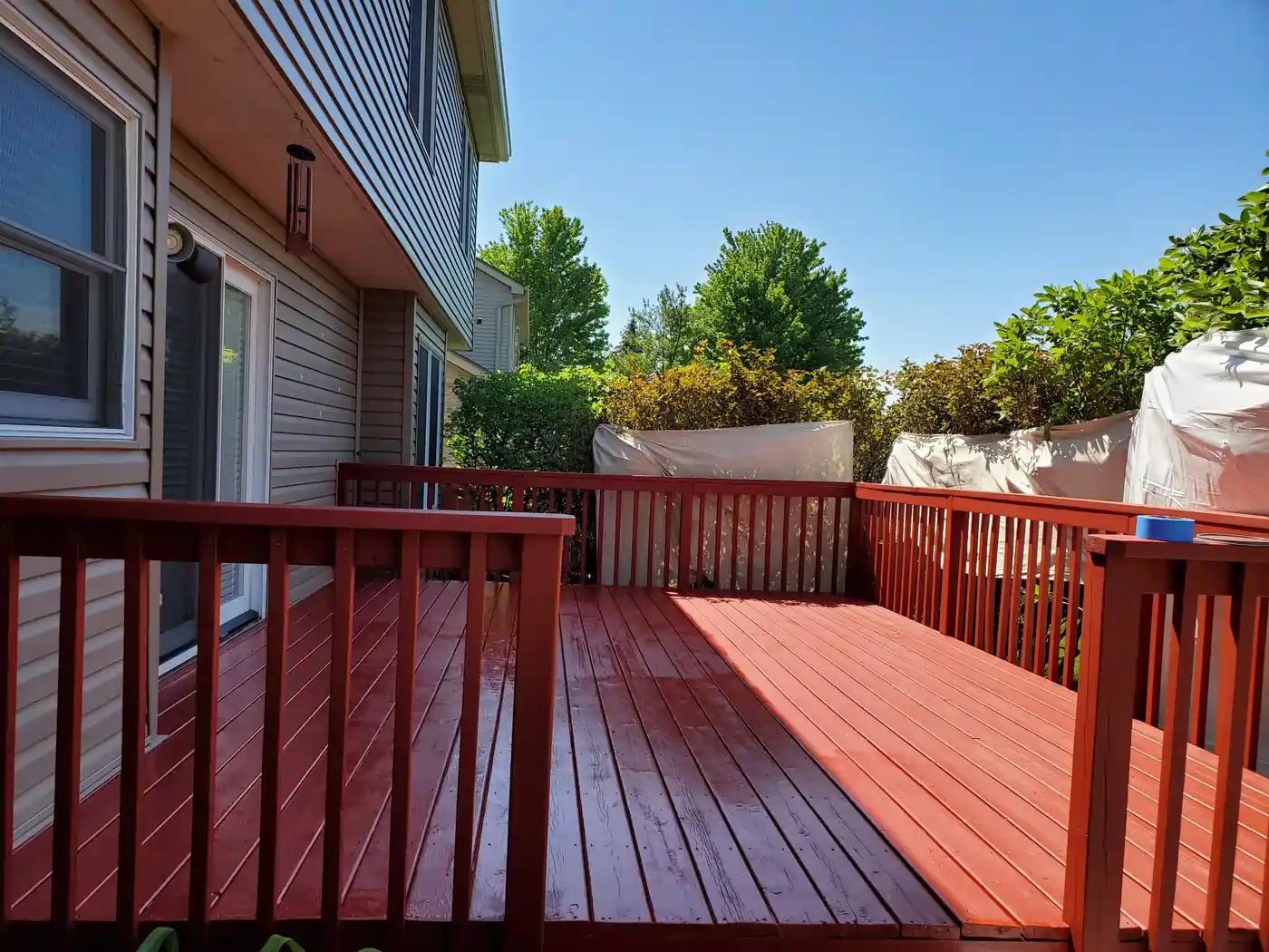 Freshly stained red wood deck by JG Home Improvement Corporation at a Naperville area home.