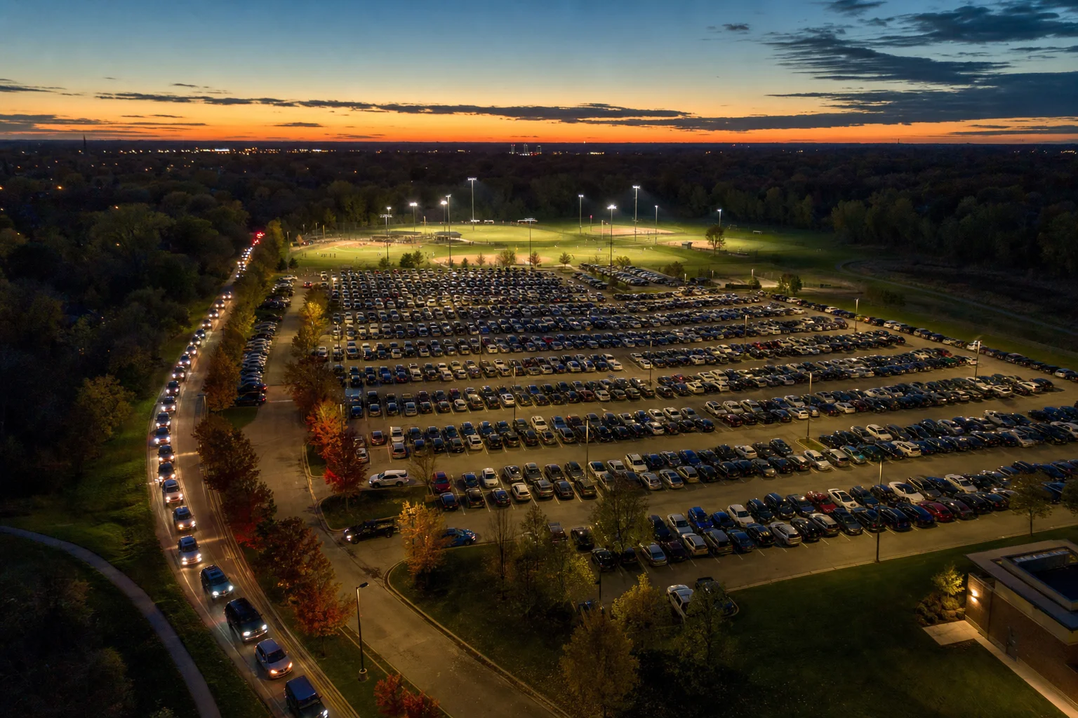 Naperville 4th of July 2026 fireworks parking - full lot at dusk at a suburban sports complex