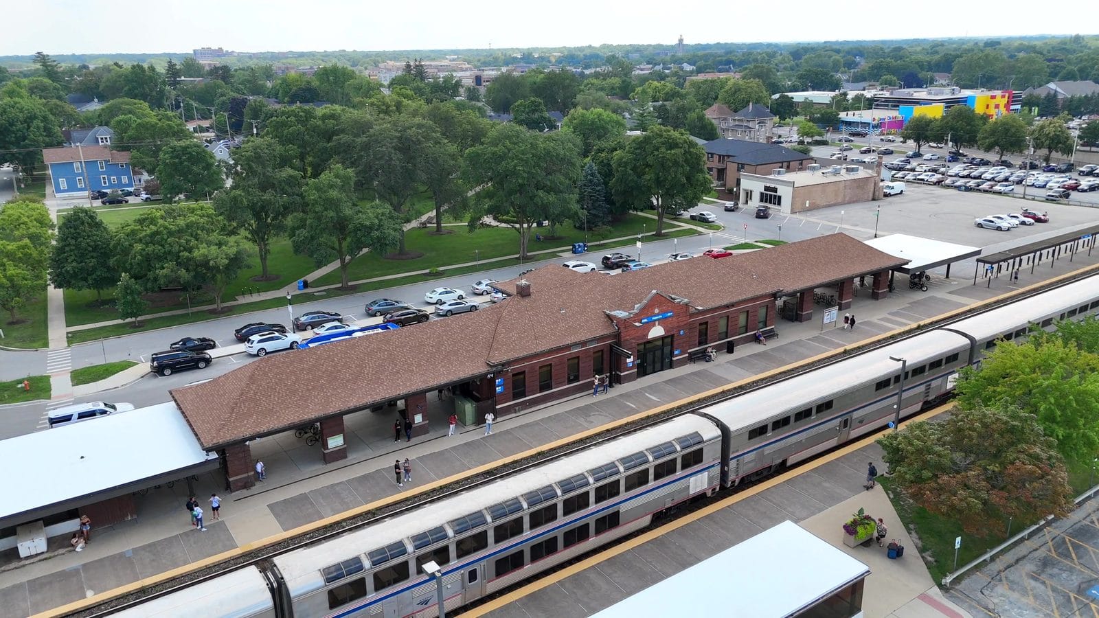 Aerial view of the downtown Naperville Metra station depot, platforms and a double-deck passenger train