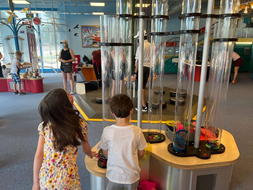 Children explore a hands on air tube exhibit inside DuPage Childrens Museum in Naperville, Illinois, highlighting family activities, STEM learning, and things to do in Naperville