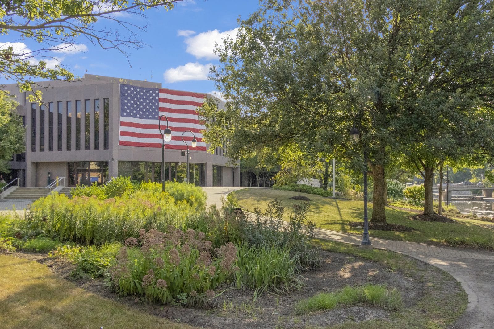 City steps before closing in Naperville: large building with an American flag by the Riverwalk