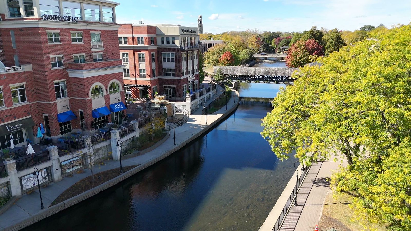 Naperville Halloween and Fall Events 2026: Things to Do Oct 10 to Nov 5 3 Water Street brick buildings with blue awnings and patios along the Naperville Riverwalk