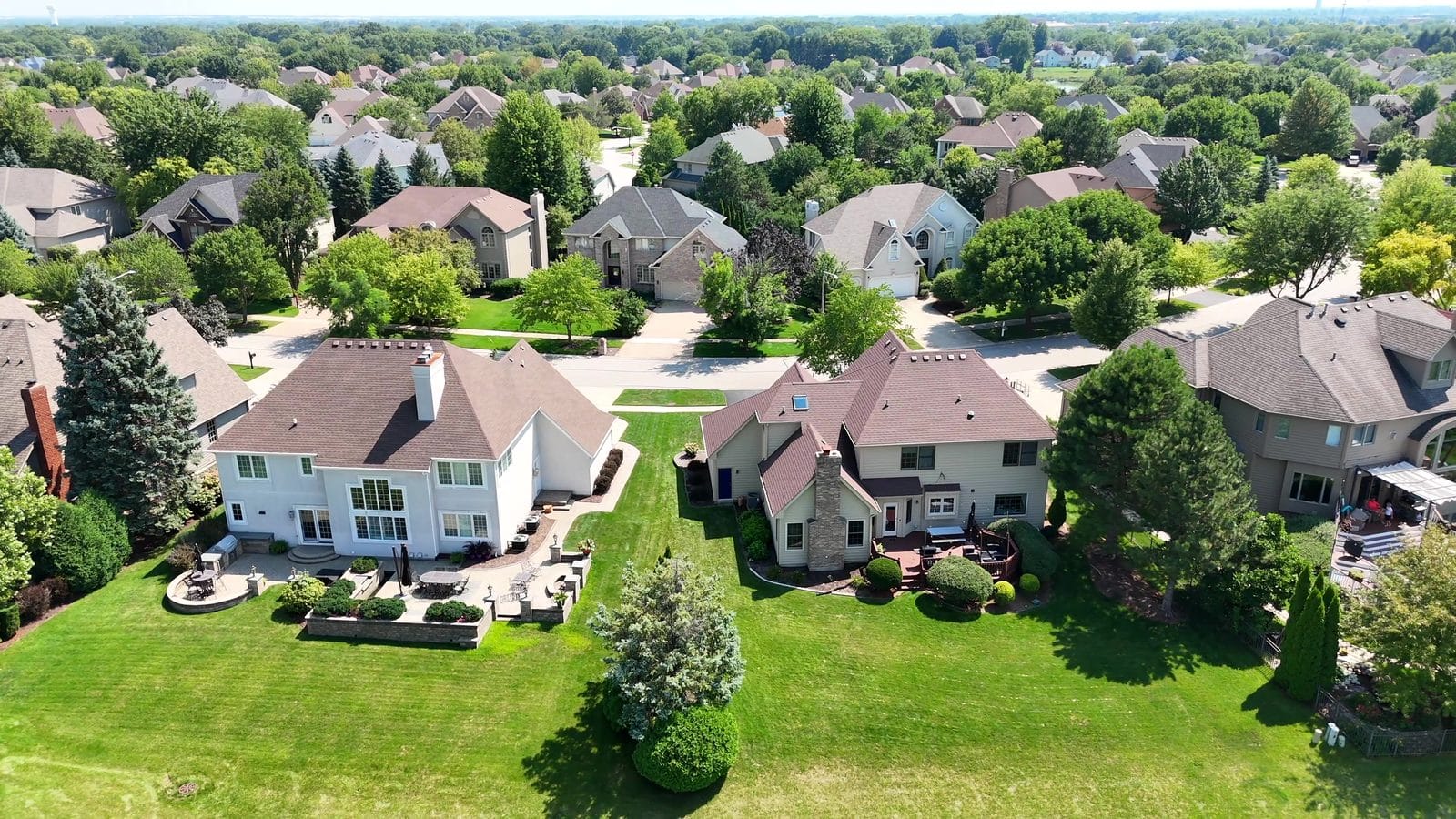 Aerial view of two-story Naperville homes, roofs and backyards buyers review after a home inspection