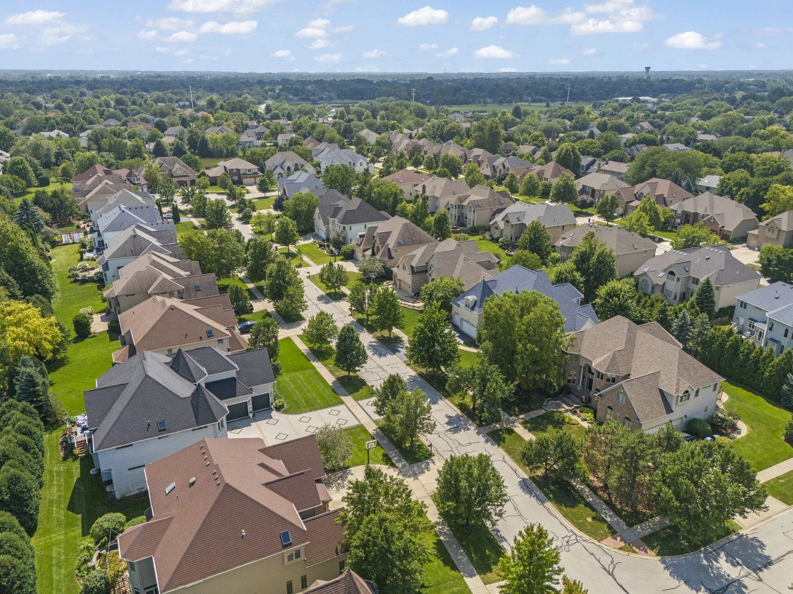 Aerial view of an established Naperville subdivision of two-story single-family homes on tree-lined streets