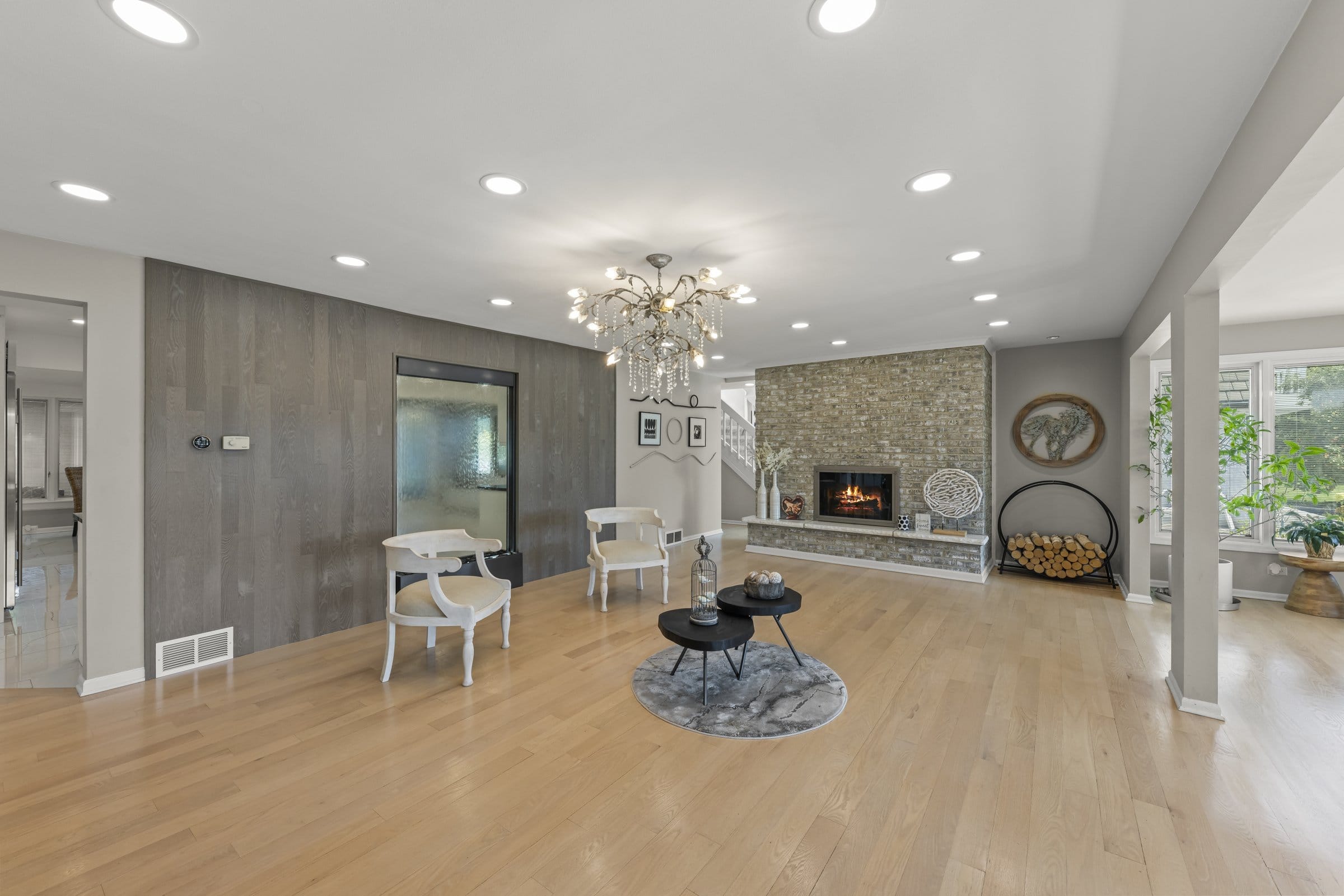 Naperville Luxury Home for Sale: 23W735 Hobson Road, a 2.65-Acre Estate with Indoor Pool and Tennis Courts 8 Living room with stone fireplace and chandelier in this 23W735 Hobson Rd Naperville estate