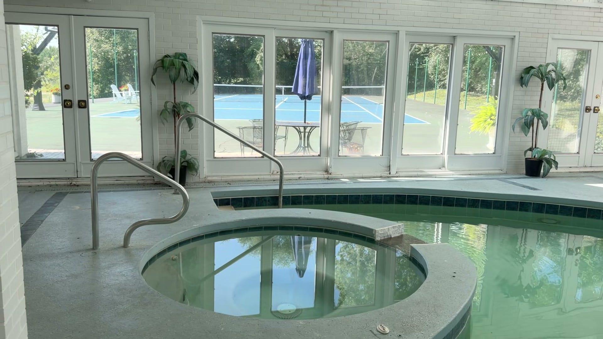 Naperville Luxury Home for Sale: 23W735 Hobson Road, a 2.65-Acre Estate with Indoor Pool and Tennis Courts 6 Indoor pool and whirlpool with the tennis court visible through glass doors in Naperville