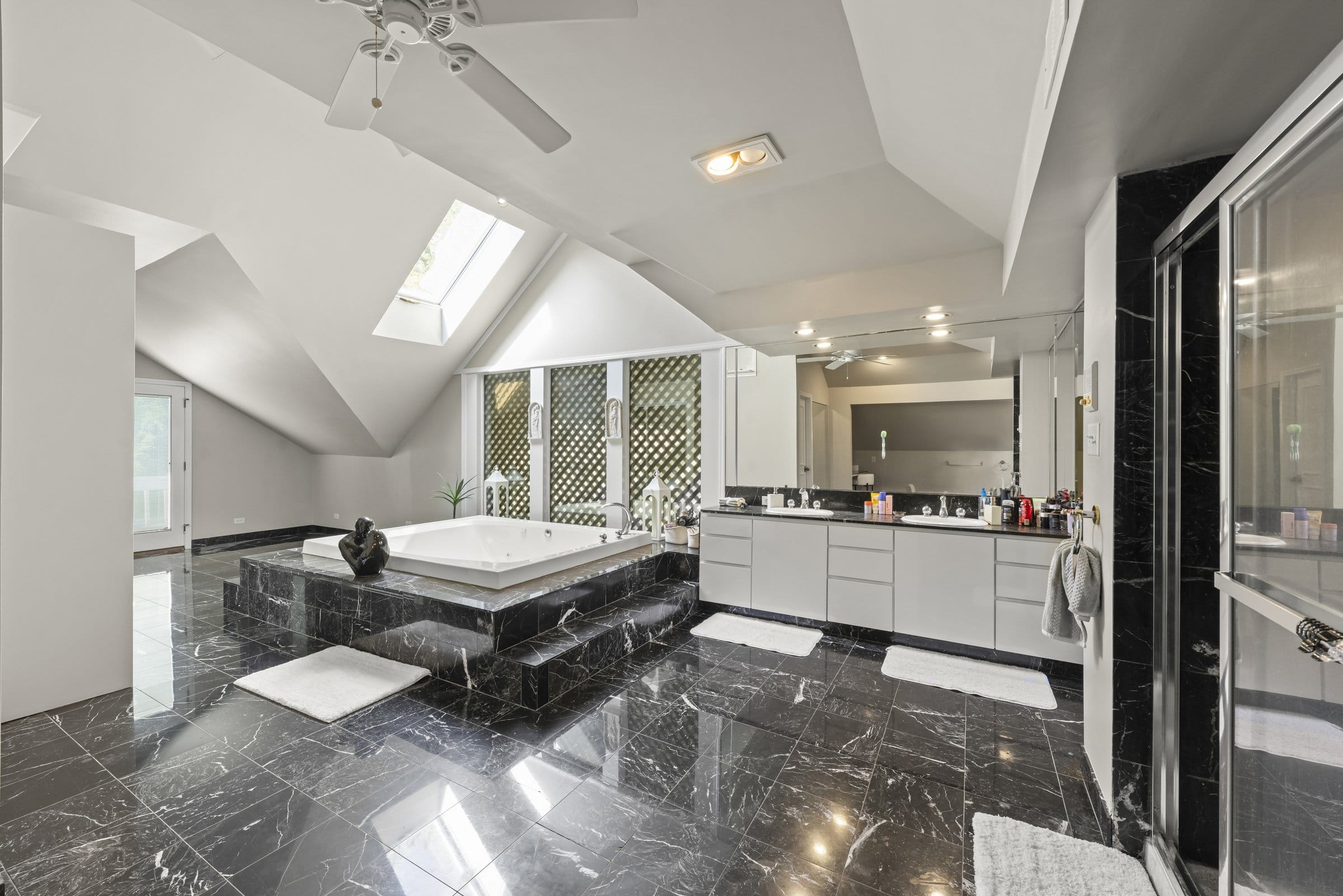 Naperville Luxury Home for Sale: 23W735 Hobson Road, a 2.65-Acre Estate with Indoor Pool and Tennis Courts 14 Primary bath with black marble floor, raised jetted tub and skylight at 23W735 Hobson Rd