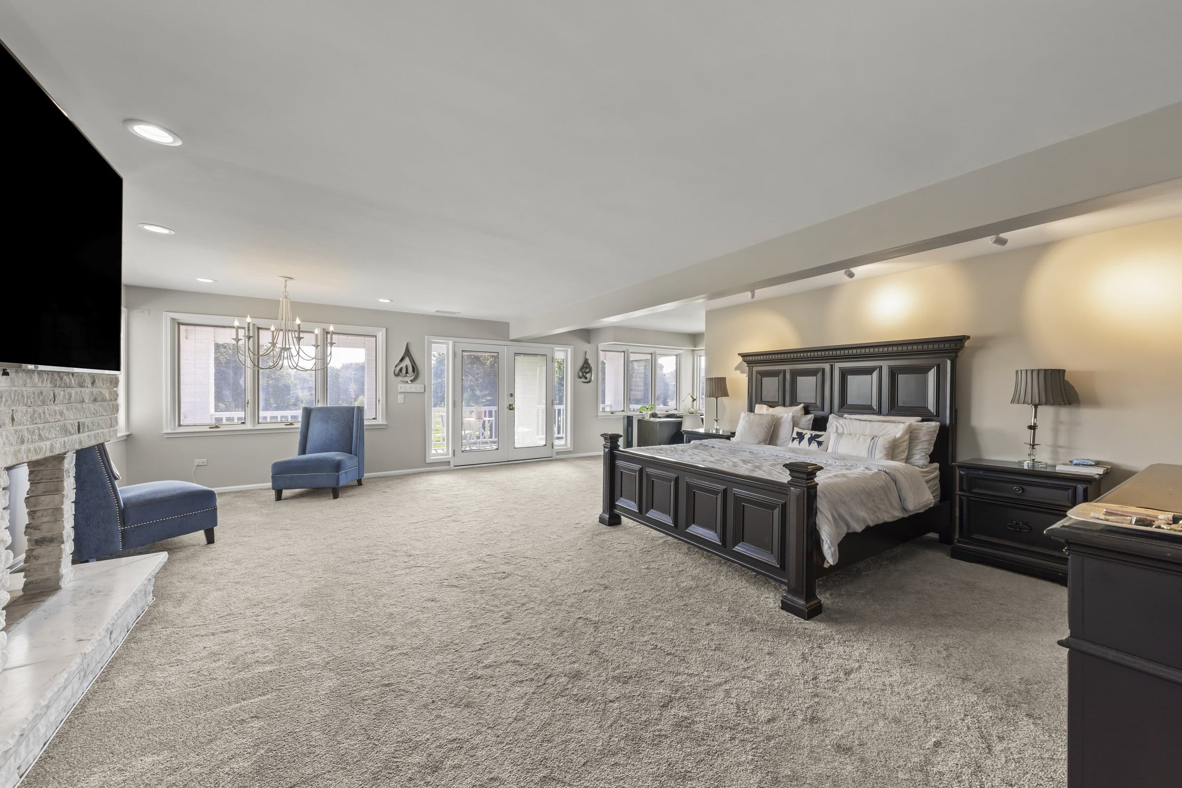 Naperville Luxury Home for Sale: 23W735 Hobson Road, a 2.65-Acre Estate with Indoor Pool and Tennis Courts 13 Primary bedroom with stone fireplace and French doors to a covered balcony in Naperville