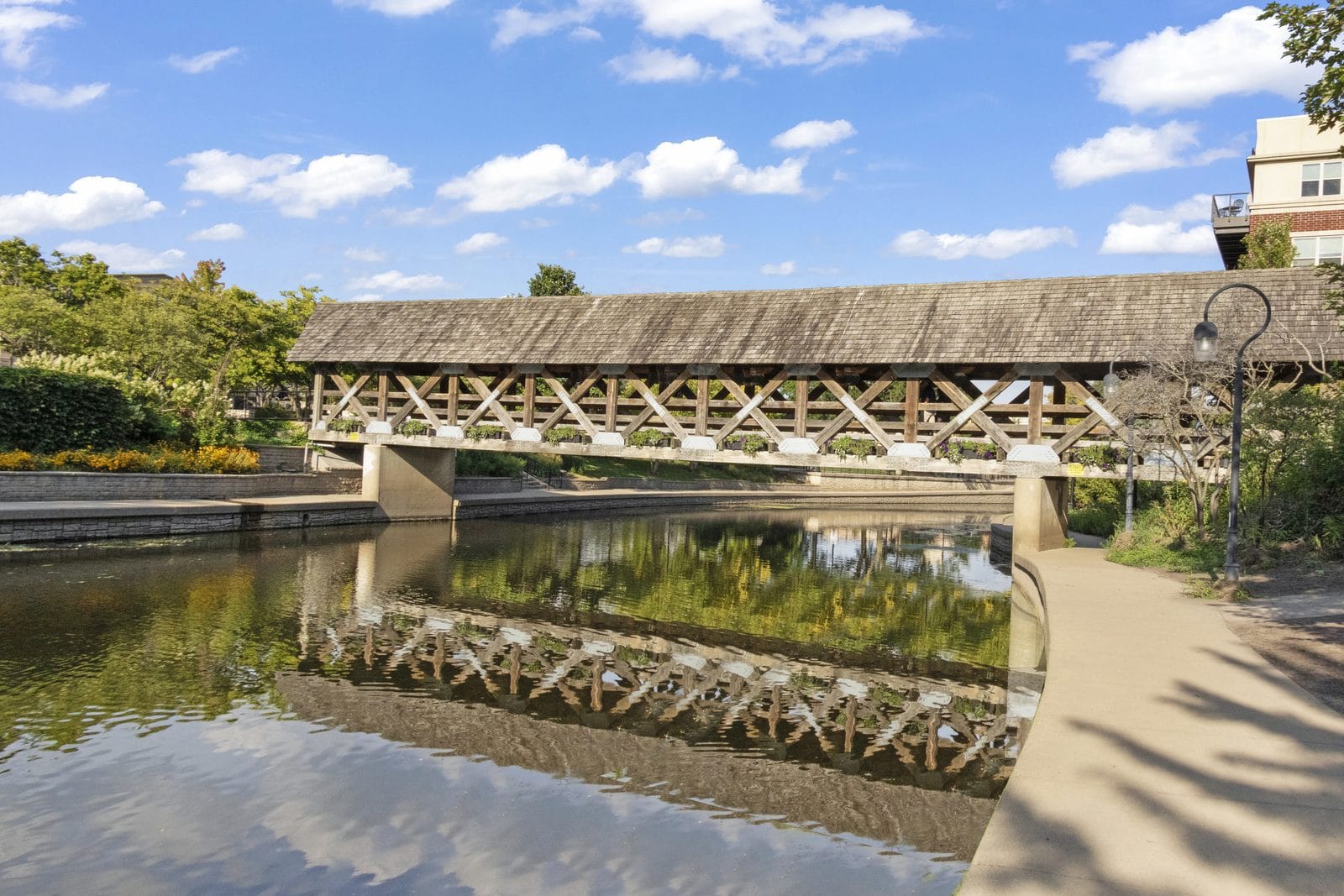 Wooden covered pedestrian bridge over the water on the Riverwalk in downtown Naperville