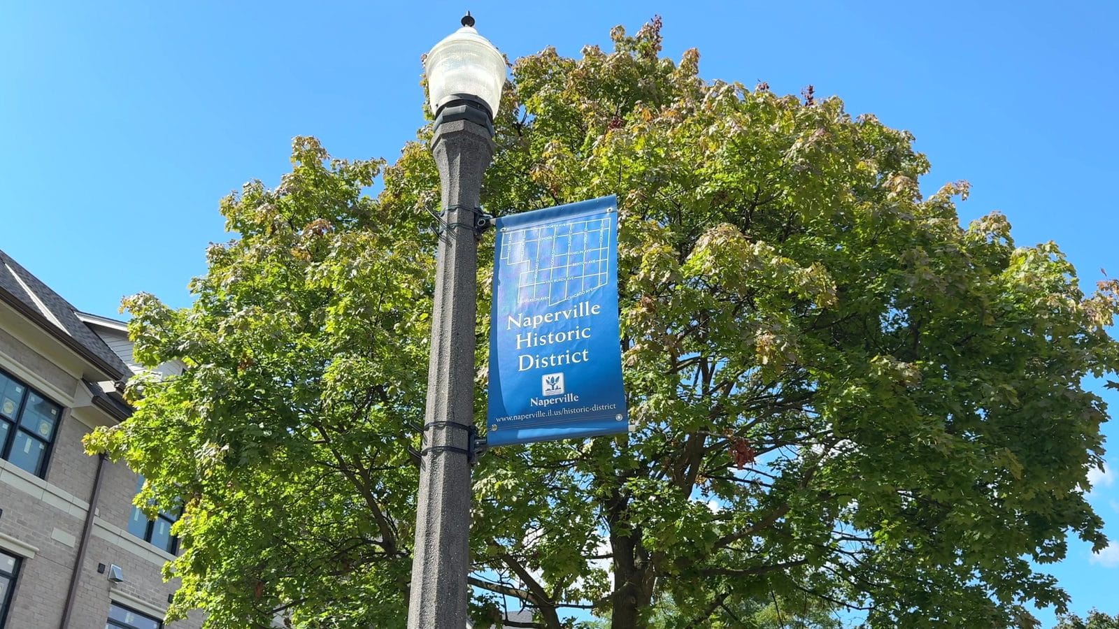 Naperville permit records: blue Historic District banner with a street map on a lamppost