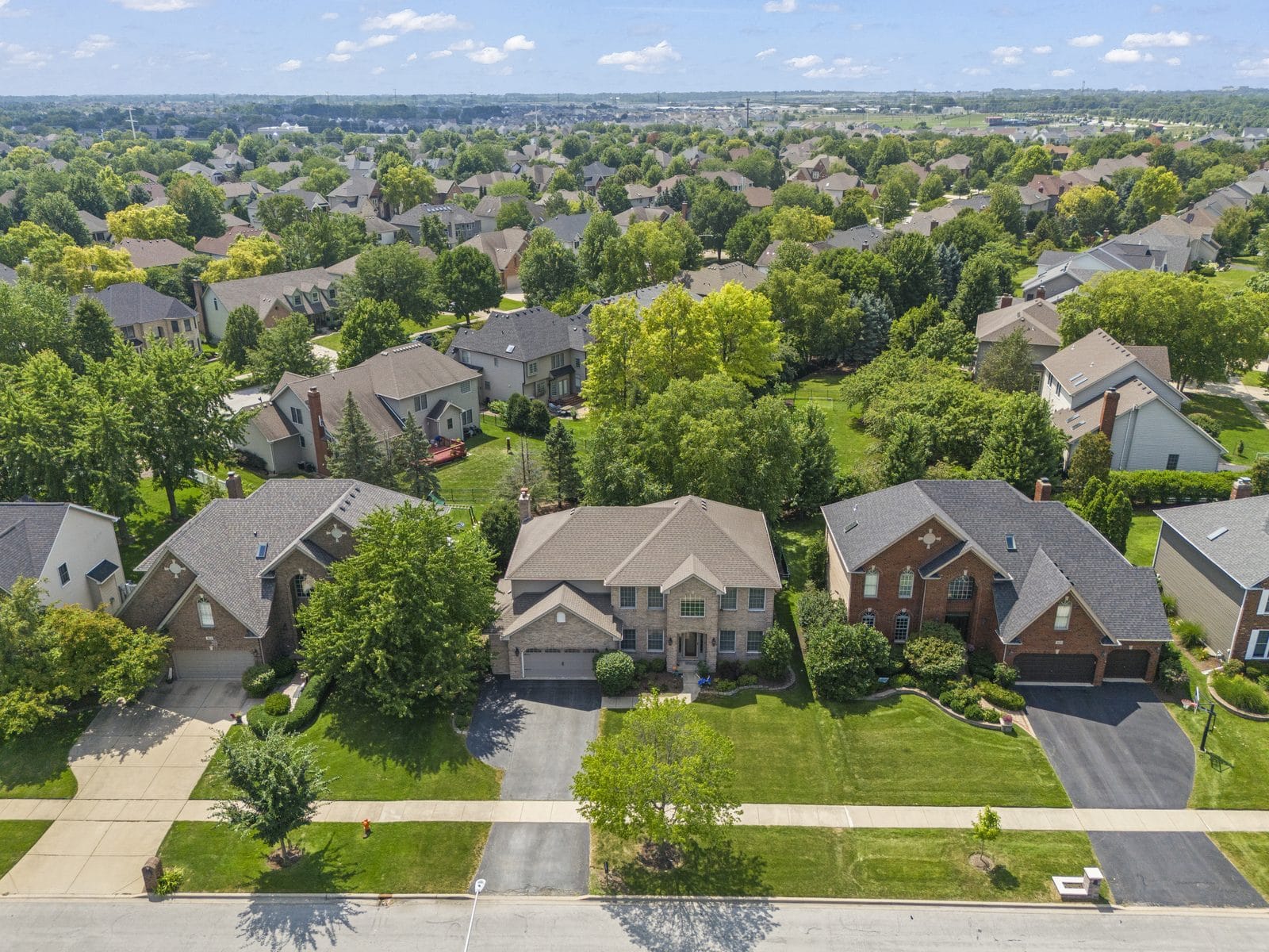 Naperville Family-Home Neighborhood, Aerial View From Above the Street Aerial view of two-story Naperville family homes with front lawns on a residential street