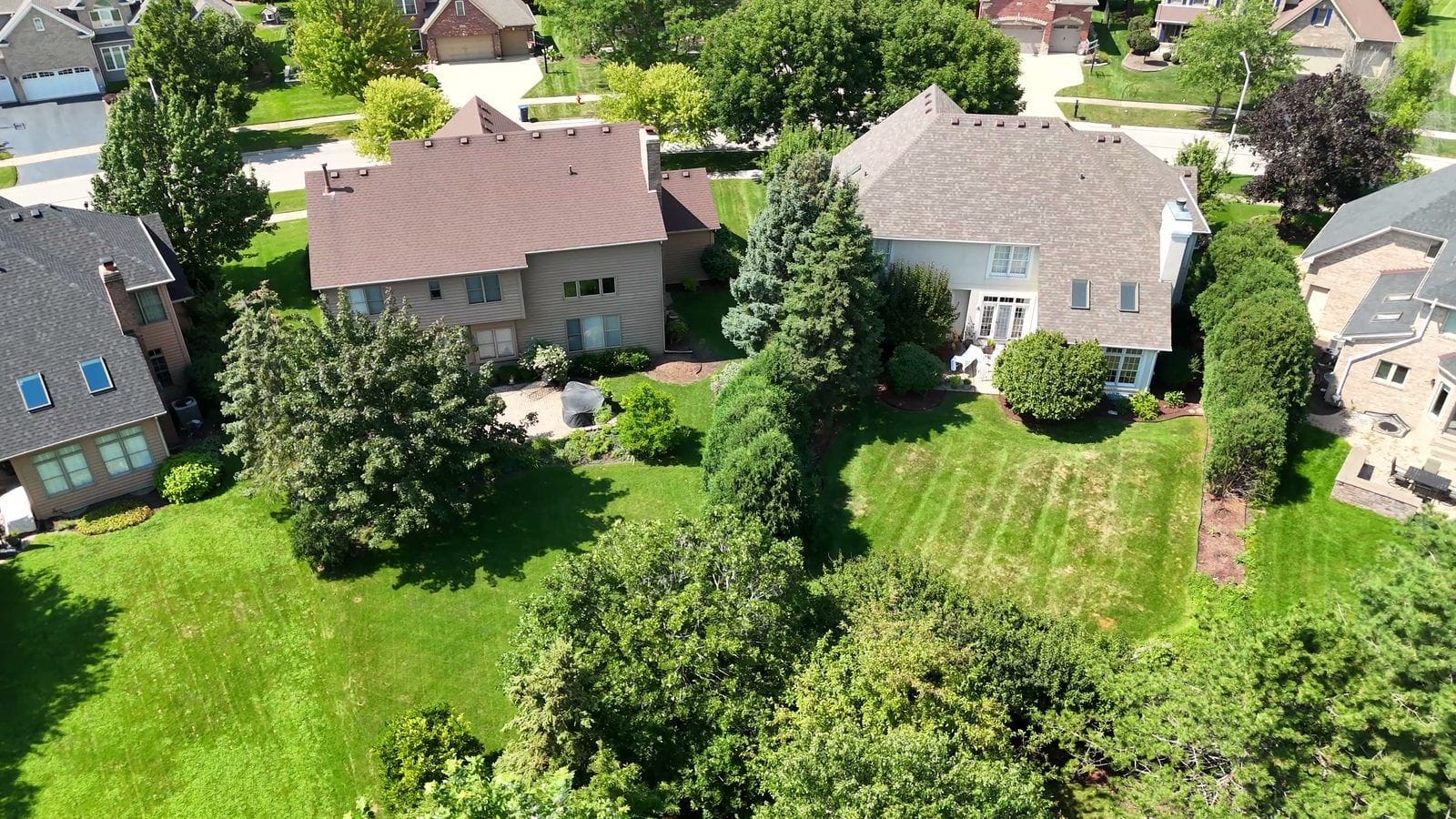 Close aerial of two finished two-story Naperville homes, roofs and rear walls, for phase inspections