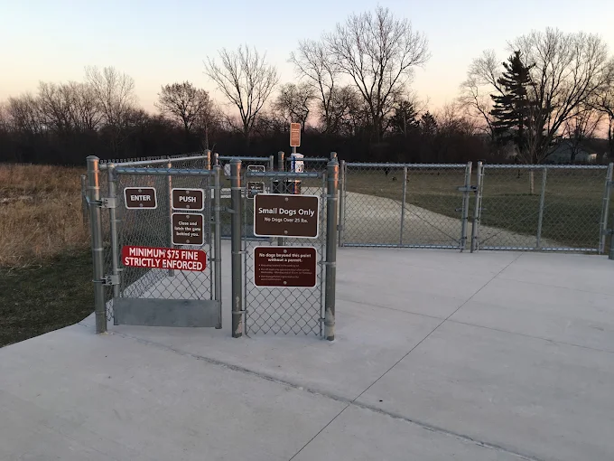 Small dog area entrance at Oldfield Oaks Dog Park near Naperville, Illinois with fenced gate and paved access.