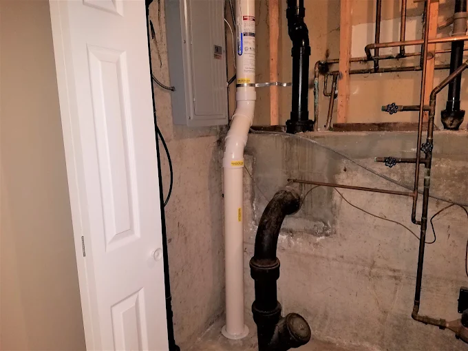 Basement radon mitigation system with vent pipe installation by Pro Radon Mitigations in the Naperville area.