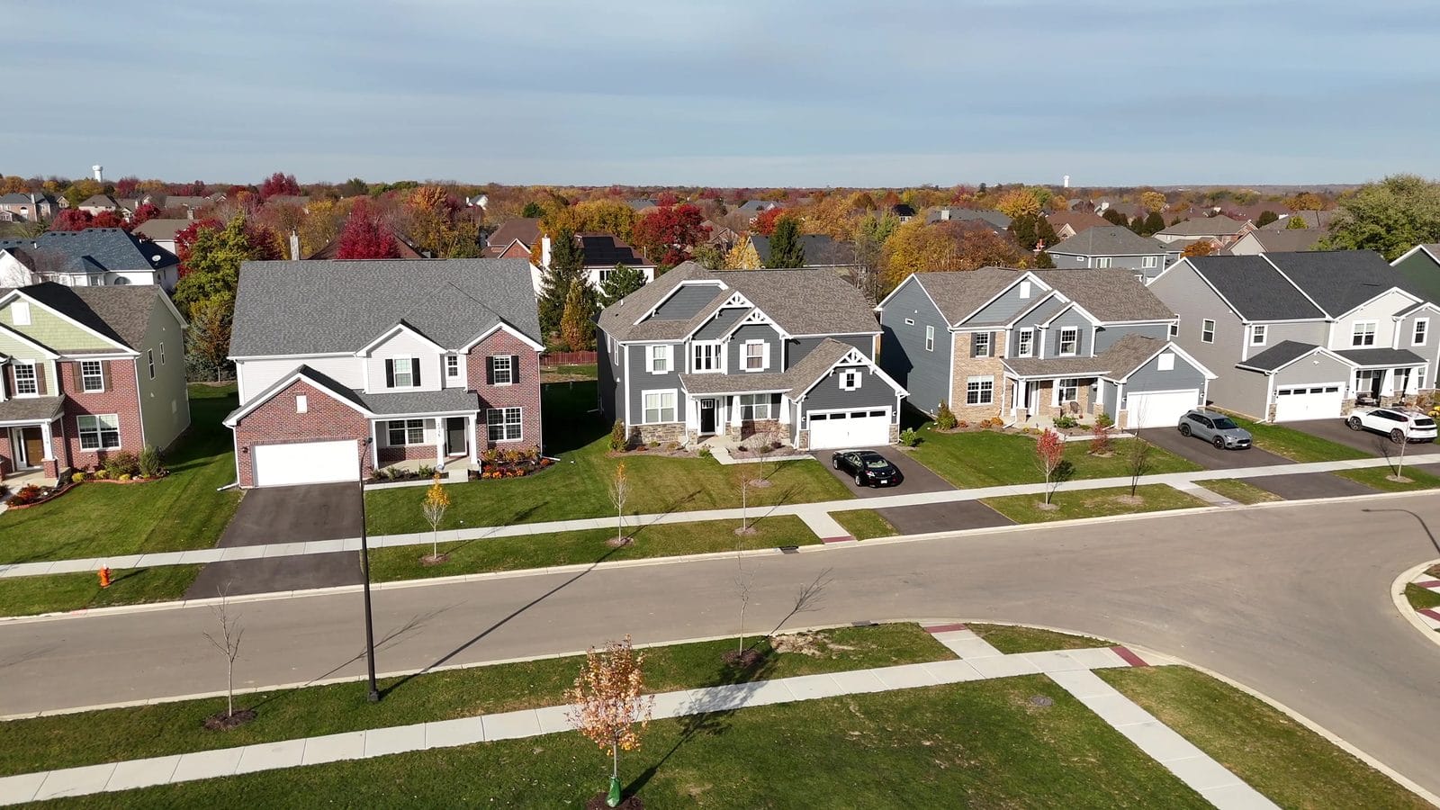 Radon testing a Naperville home: two-story houses with attached garages along a fall street