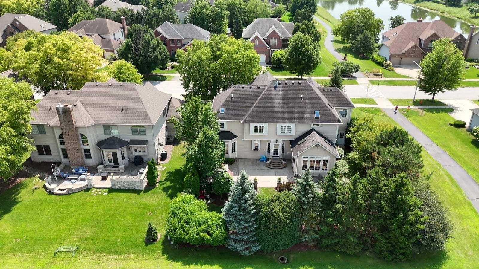 Search for a house in Naperville: aerial of Tall Grass homes near a pond path