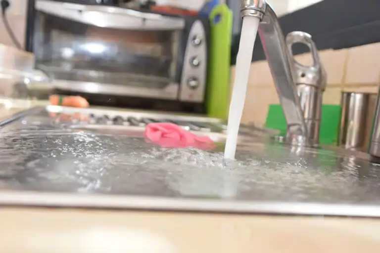 Kitchen sink with running water representing drain cleaning and plumbing service by Sewer Sharks in the Naperville area.