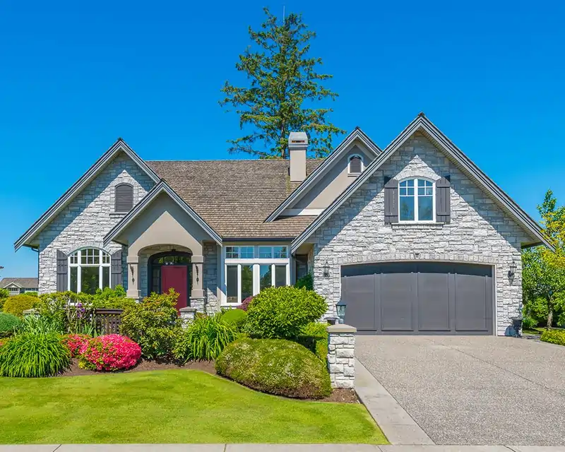 Stone home exterior with landscaped front yard representing residential inspection services by Sound Home Inspections Inc.