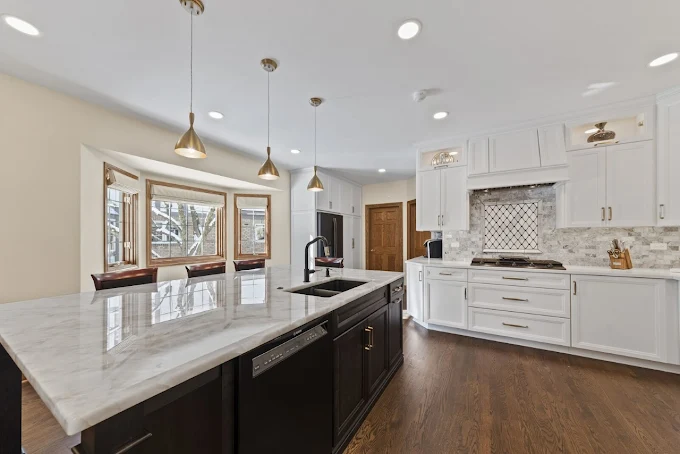 Kitchen countertop installation by TC Stone Enterprise with white stone island, custom cabinets, and tile backsplash in Naperville.