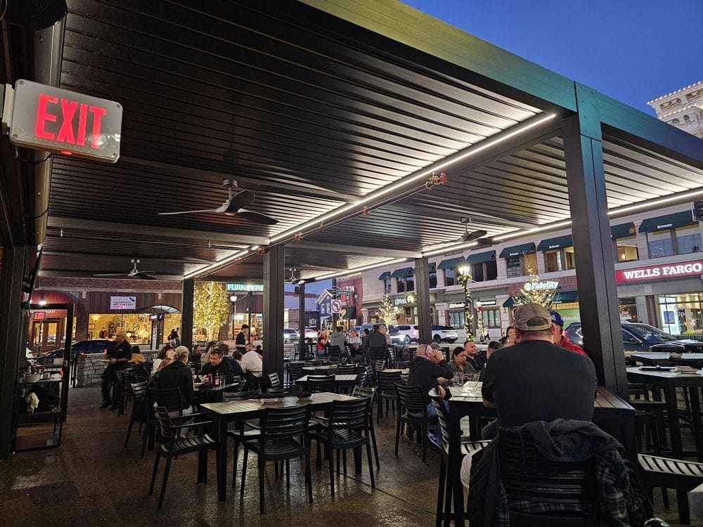 Outdoor patio dining at The George in Naperville, Illinois, featuring evening seating, covered tables, and a downtown Naperville restaurant atmosphere