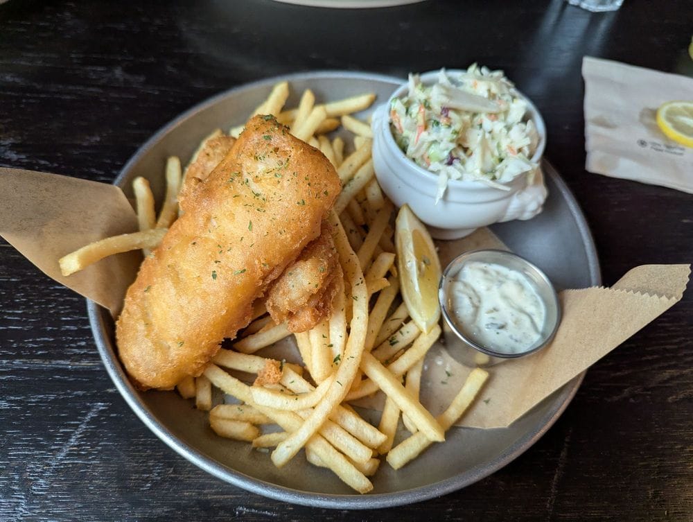 Fish and chips with fries, coleslaw, tartar sauce, and lemon served at The George in Naperville, Illinois, highlighting local dining and Naperville restaurant favorites