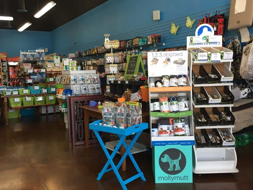 Interior of Two Bostons pet store in Naperville with dog treats, pet supplies, toys, beds, and retail displays.