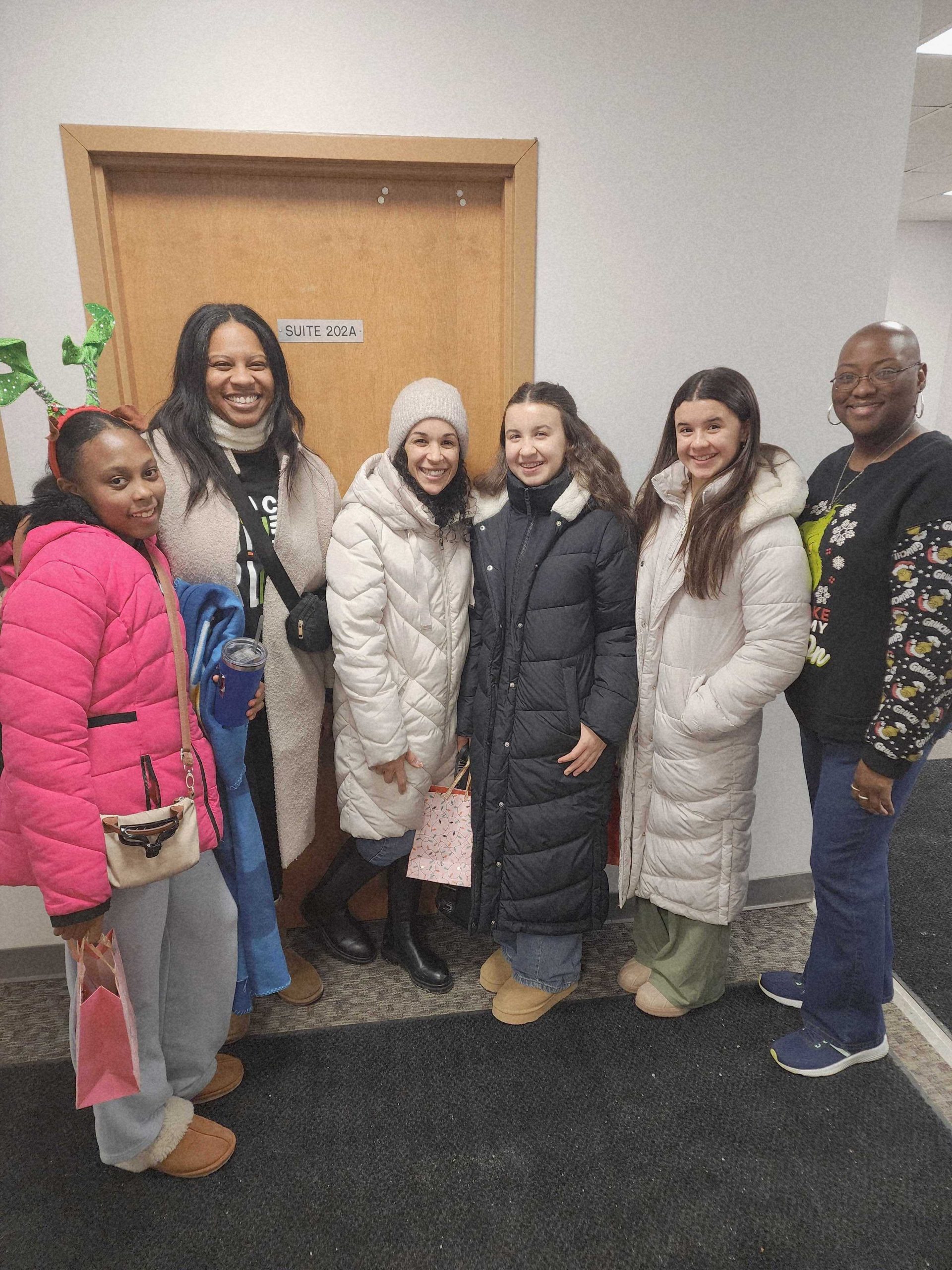 Volunteers and participants gathered during a Beautifully EmpowHERed holiday outreach event in Naperville, Illinois.
