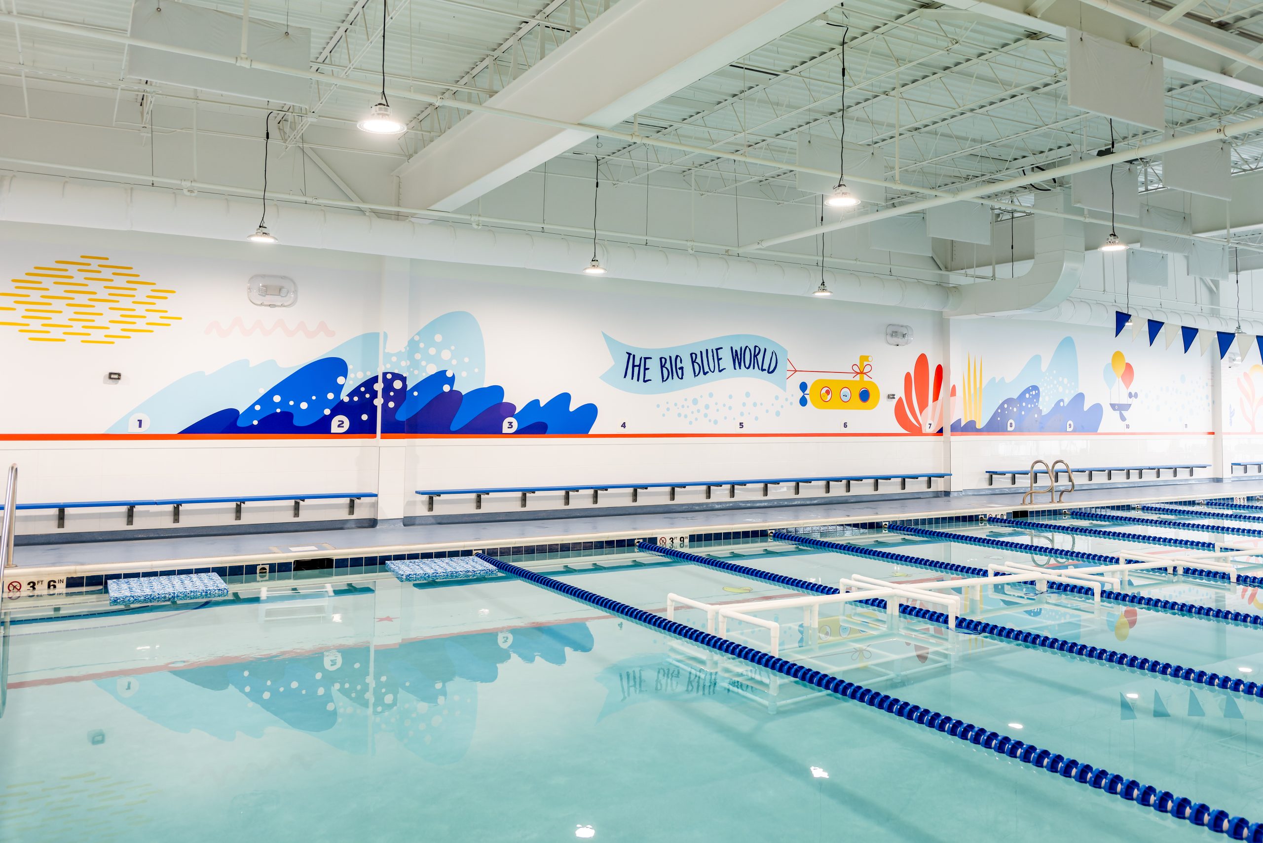Indoor swim lesson pool featuring The Big Blue World mural at Big Blue Swim School in Naperville.
