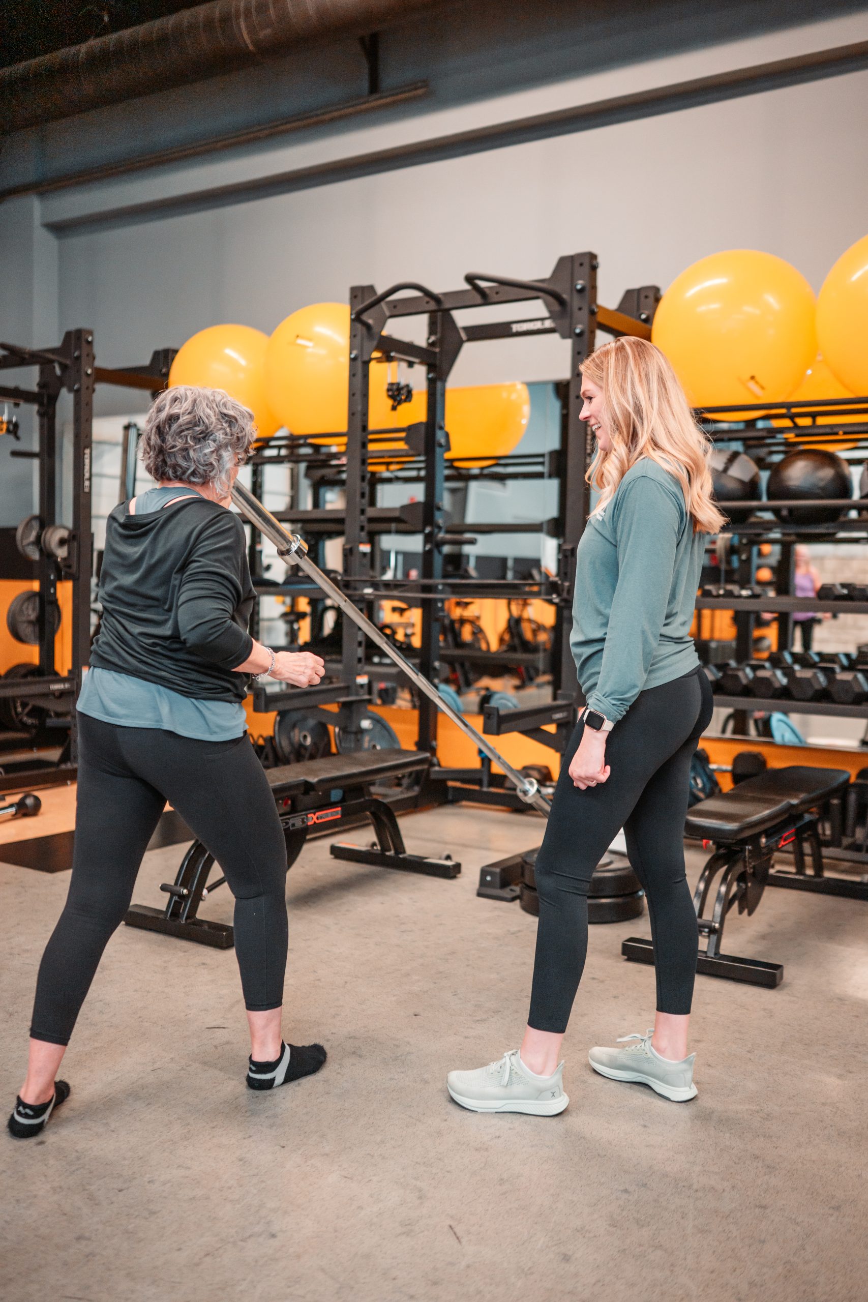 Fitness coach providing one-on-one strength training guidance to a client at Beyond Measure Fitness Training in Naperville, Illinois.