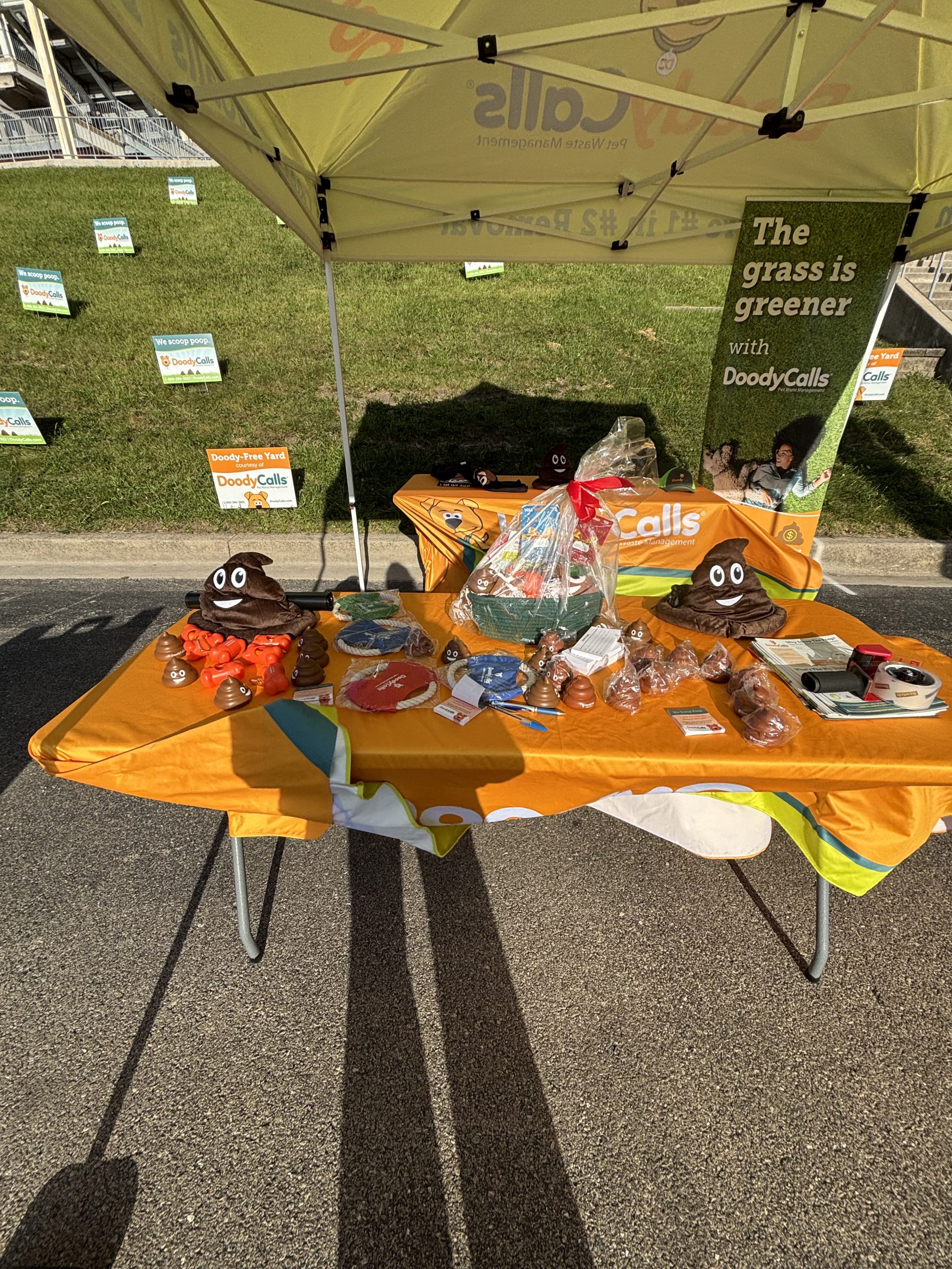DoodyCalls Chicagoland promotional table with educational materials and giveaways at a Naperville community event.